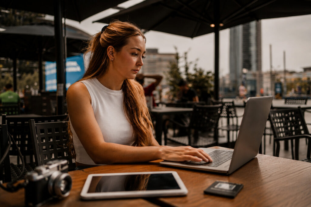 A freelancer using a laptop on coffee shop public Wi-Fi with encrypted VPN protection.